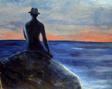 un homme sur un rocher face à la mer